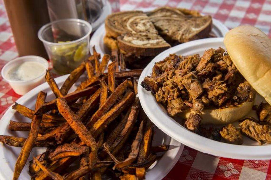 The Ol’ Smoky burnt ends sandwich, lower right, and the Big D sandwich, top, with sweet potato fries, at Danny Edward’s BBQ, 2900 Southwest Blvd.