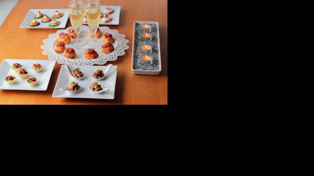 
Toast 2015 with a sampling of lucky appetizers, including kale (the color of money), lentils (the shape of money), doughnuts (a circle), black-eyed peas (traditional) and salmon (to represent moving foward). 

