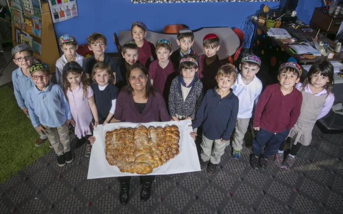 Jewish studies teacher Nira Solomon shares the art of Hanukkah challah with kindergarteners
