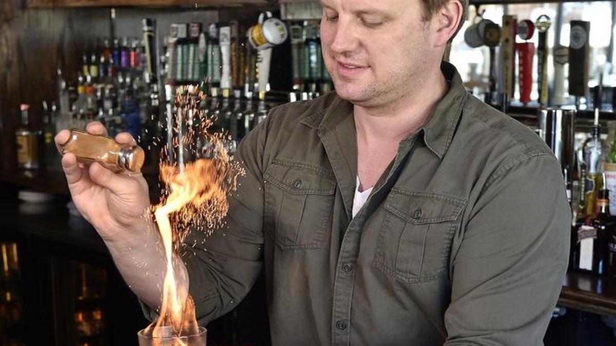 Eddie Crane demonstrates a cinnamon flambe, part of the rum punch at Ollie’s Local. It’s one of several punches the bar serves that are based on the drink’s classic recipe.