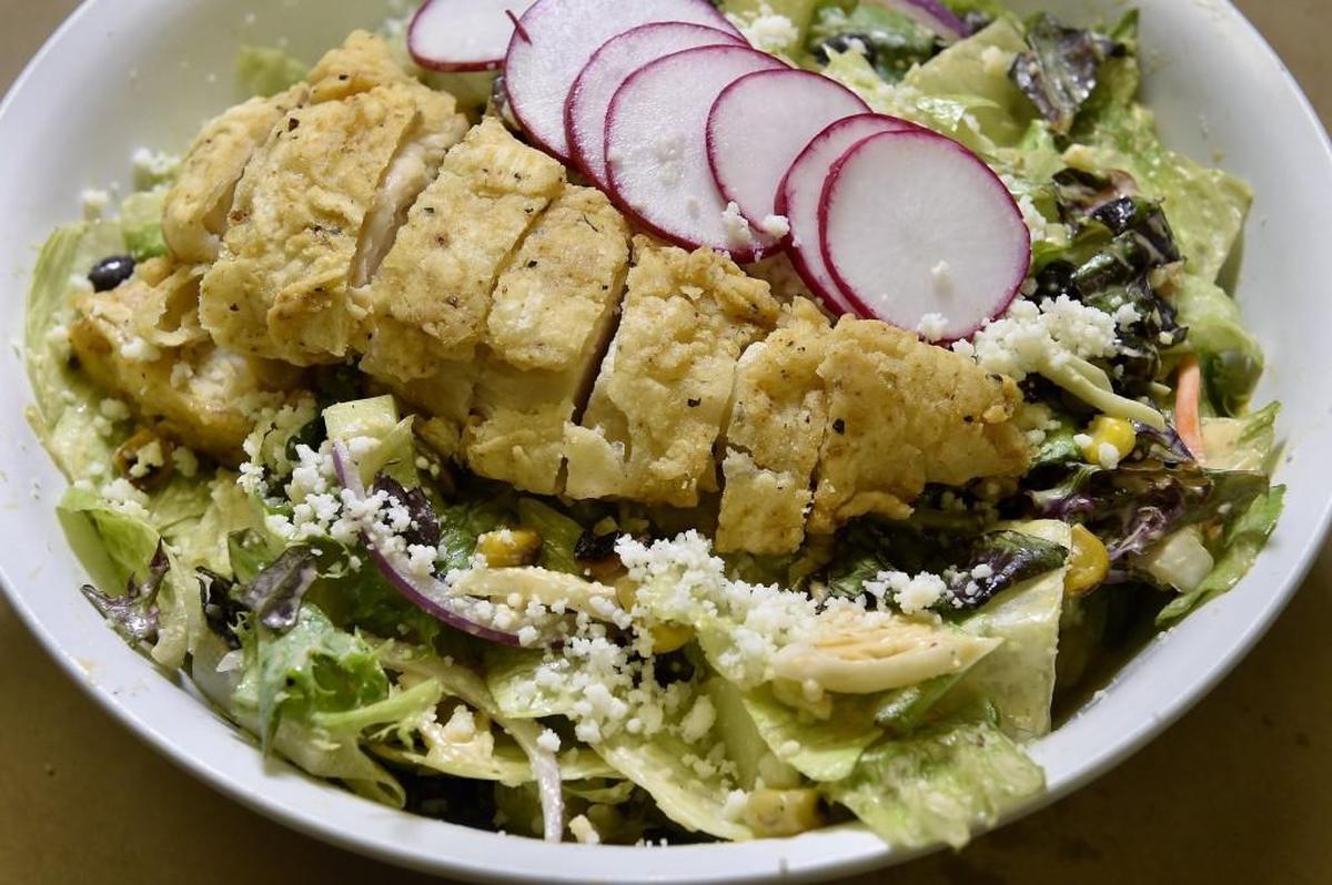 Fried Chicken Salad: house lettuce blend, roasted corn, fresh cucumber, pinto beans, mint and housemade chipotle-ranch dressing.