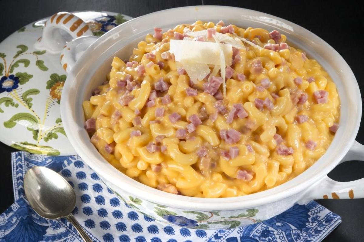 Macaroni and cheese topped with cubed ham.