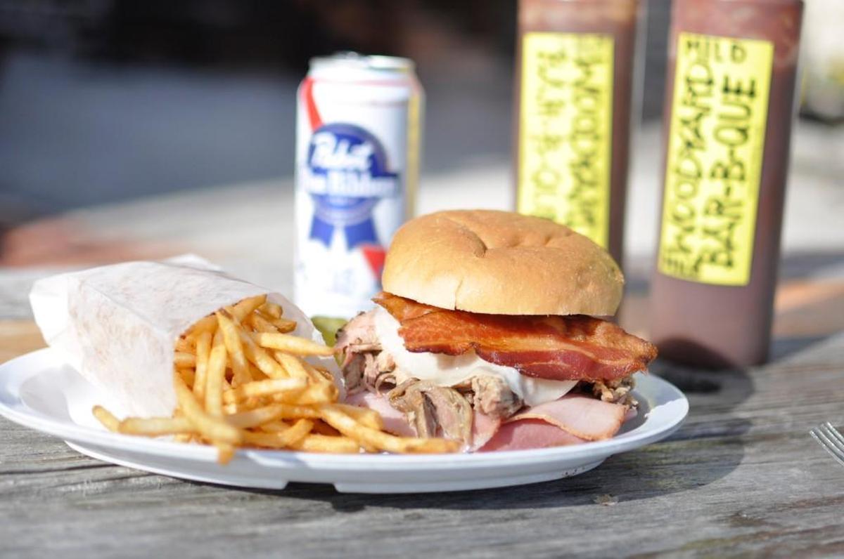 Woodyard Bar-B-Que’s Triple P sandwich is piled high with pulled pork, smoked ham and bacon. It comes with a side of coleslaw, beans or shoestring fries.