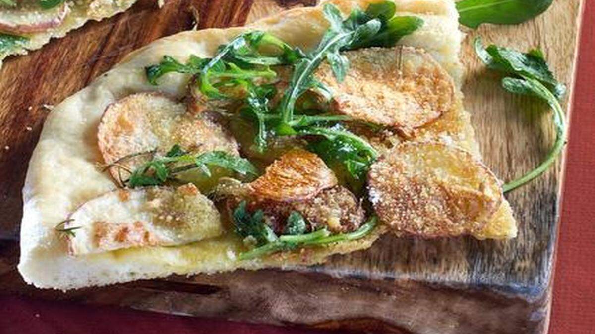 
Potato pizza with arugula is a deliciously unconventional and elegant way to serve the humble spud.
