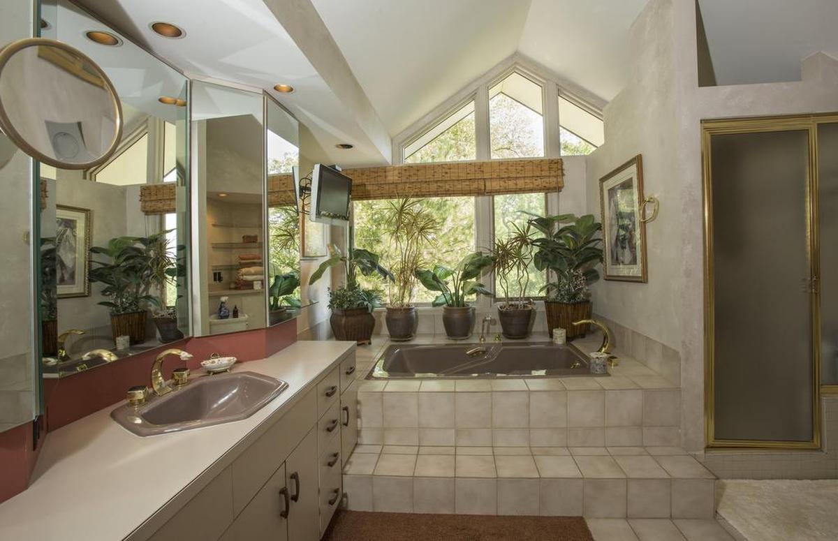 The master bath has details that are back in style today, like brass and blush.