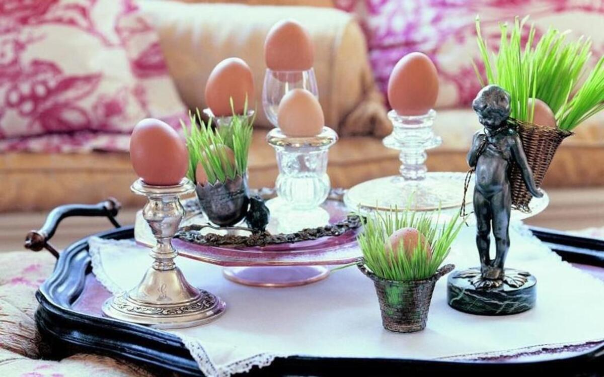 Create an Easter-y vignette on a tray by placing brown eggs atop candlesticks and in small bowls surrounded by grass.