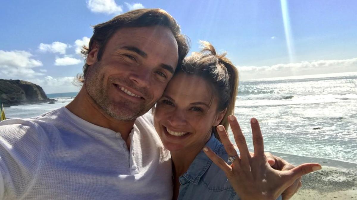 Lindsay Archer shows off the engagement ring Matt Blashaw surprised her with at the site where he proposed, a beach in Dana Point, Calif.