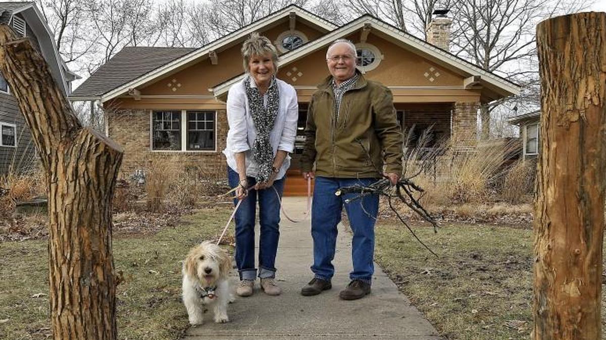 Artists Brownie and Rich Hayek (shown with their dog, Star) placed two Osage Orange trunks in front of their home in the Ward Parkway-Waldo corridor.