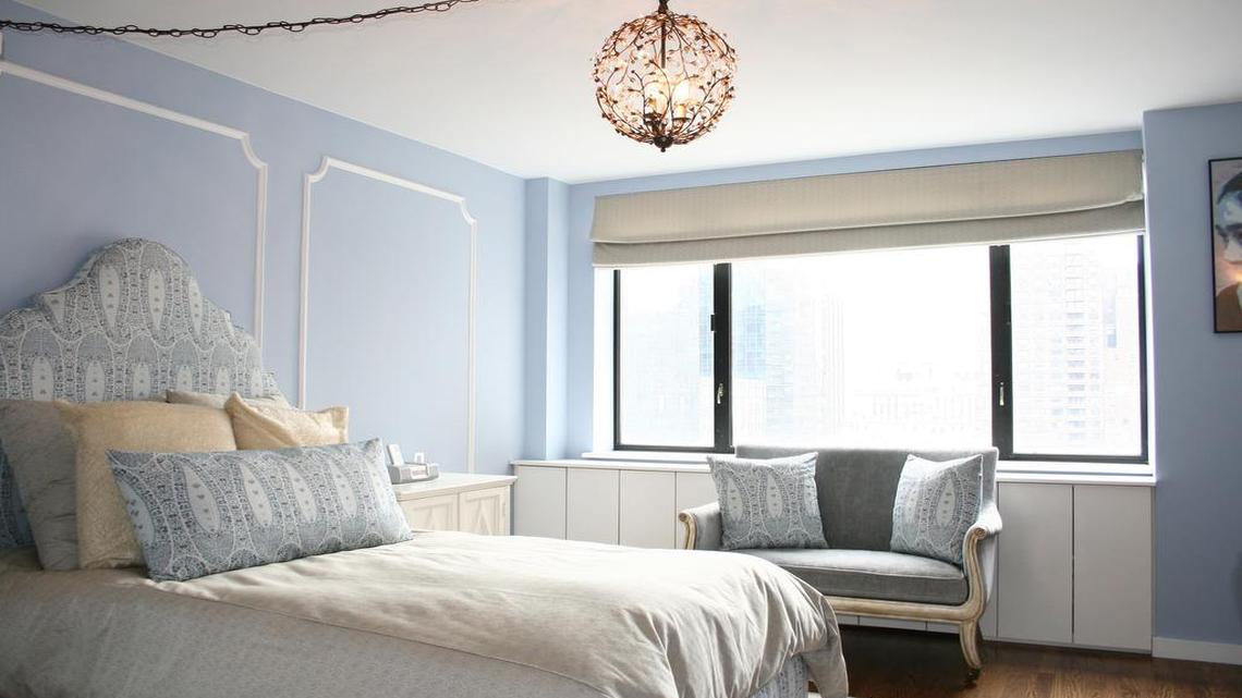 A Serenity blue bedroom paired with white creates a sense of Hollywood glam.