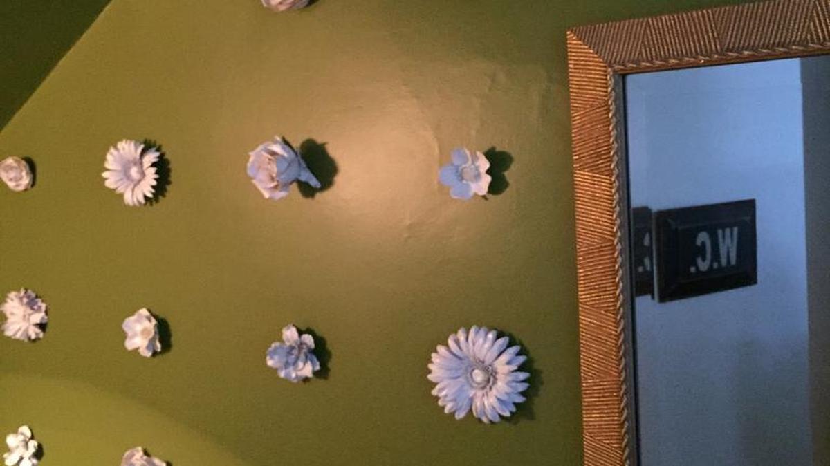 
Michelle Stark Kaufman covered silk flowers with glossy white spray paint to resemble enamel or ceramic flowers and attached them to her powder-room walls.
