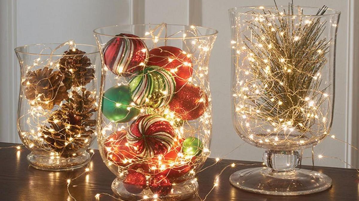 Cordless micro-light strings can be woven around ornaments, pine cones or glittery branches that sit in glass vessels.