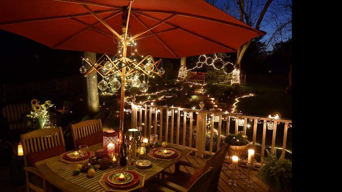 
Karen Oatman strung a 10-foot strand of thin wire LED lights ($13, Home Depot) above her patio table. The battery-operated lights are attached, along with clear glass balls, to an antique French folding laundry rack.

