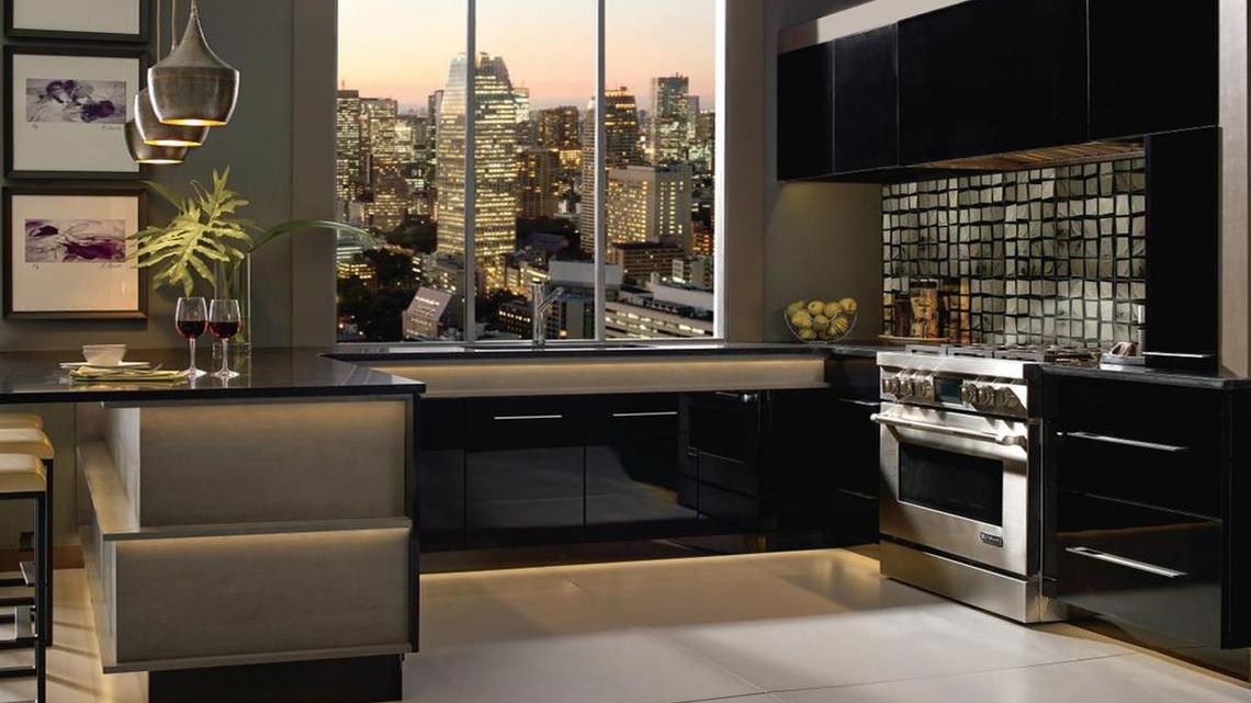
An example of MasterBrand Cabinets’ high-gloss painted cabinets in striking black reflects sophisticated glamour in an apartment. 
