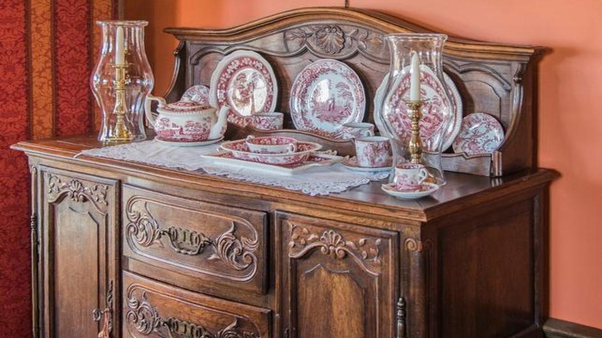 China on a restored side board, brass sconces and a still-life painting harken to an earlier time.