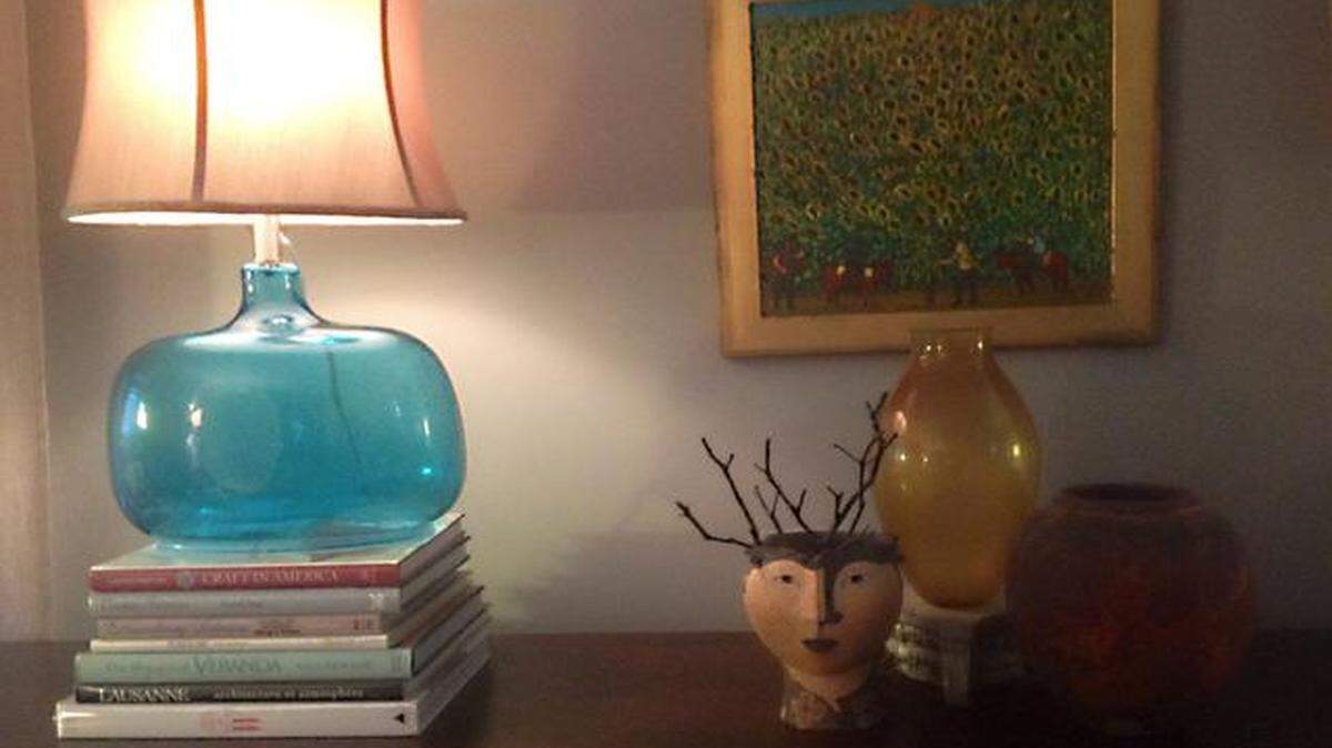 
Raising the amber glass vase on a concrete pedestal adds interest to this vignette, as do the books beneath the lamp.
