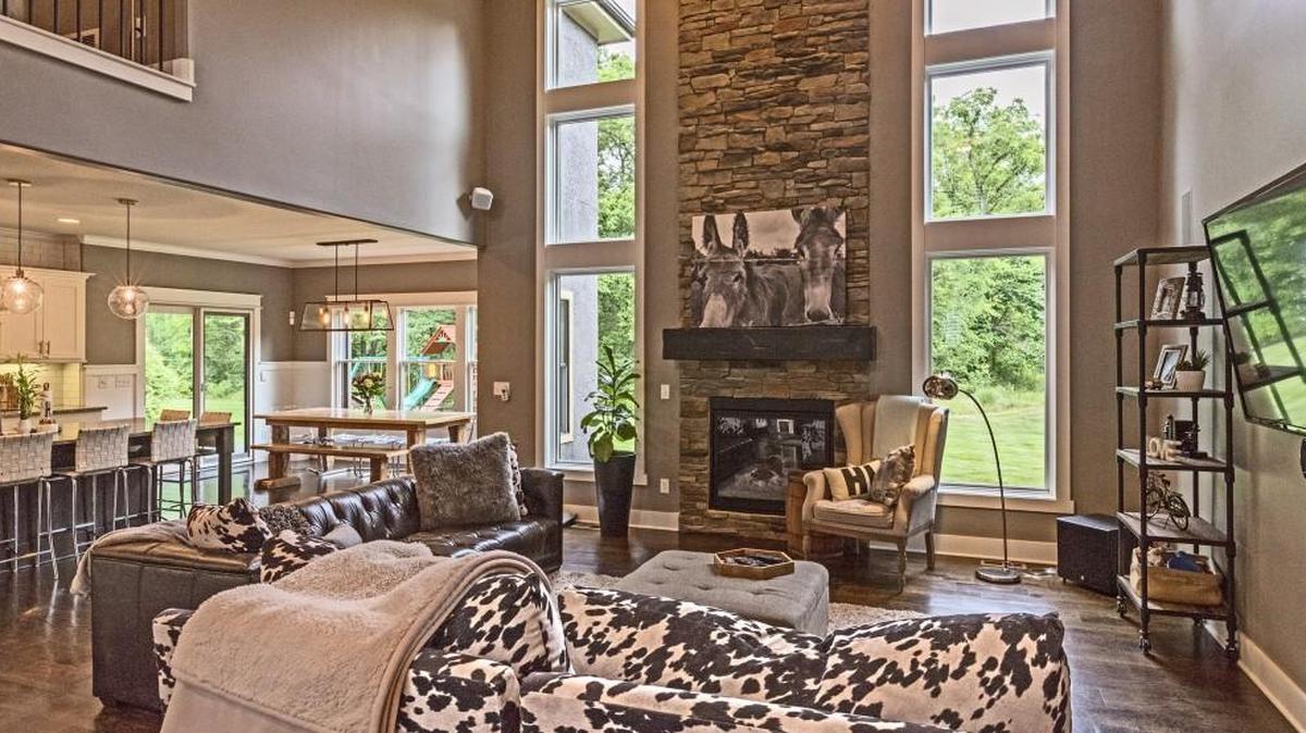 The high ceiling and large windows of the great room give an open, airy feeling to the home. Many visitors comment on the whimsical donkey photograph above the fireplace.