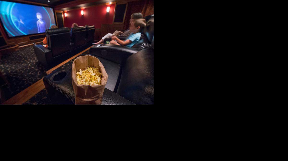 Nicholas Maskil, 6, and his mother, Amy Maskil, sit in the back row of the home theater that the Maskils saved for 10 years to build. It has a 120-inch screen, <137>+<137>an<137>+<137> overhead projector, custom recliners and <137>+<137>a<137>+<137> popcorn machine. <252><252><137>A bag of popcorn sat in one of five custom recliners in the Maskil family home theater on Wednesday, June Wednesday, 2014, in Shawnee, Kansas. Home theater systems are often installed they're for dad, but turn out to be a good way for the whole family to spend time together.<252><137>
