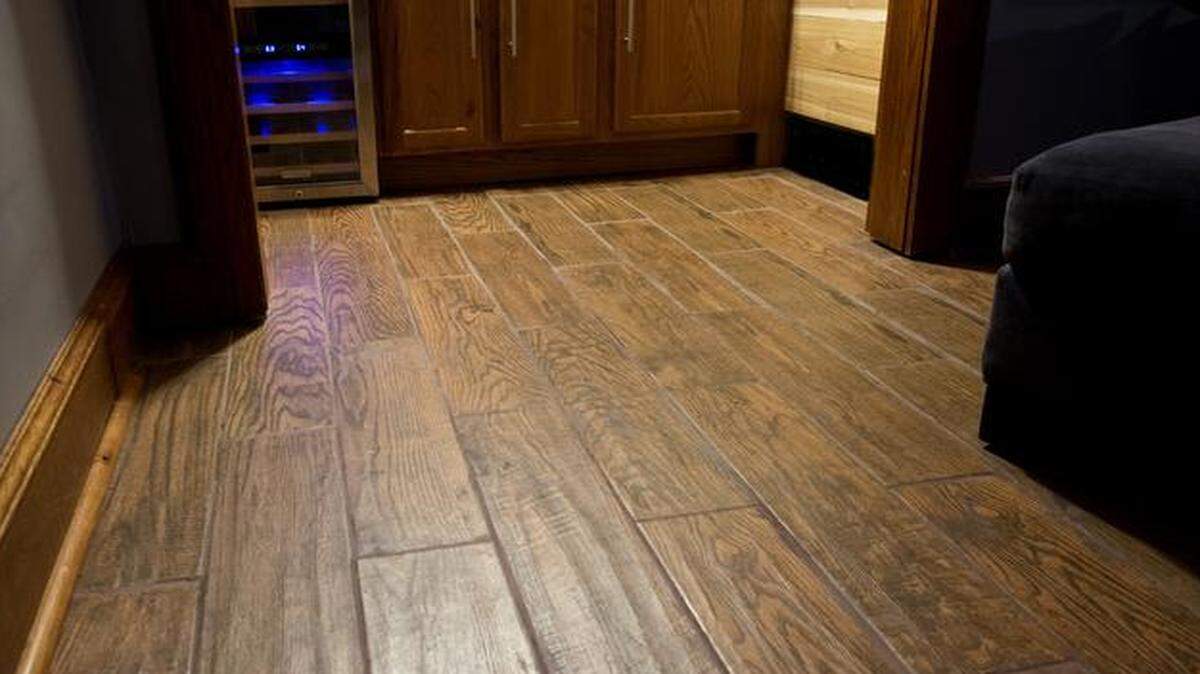 
After a flood ruined the carpet in the bar and TV room in Christian and Andrea Joseph’s Kansas City basement, they replaced it with waterproof wood grain tile.


