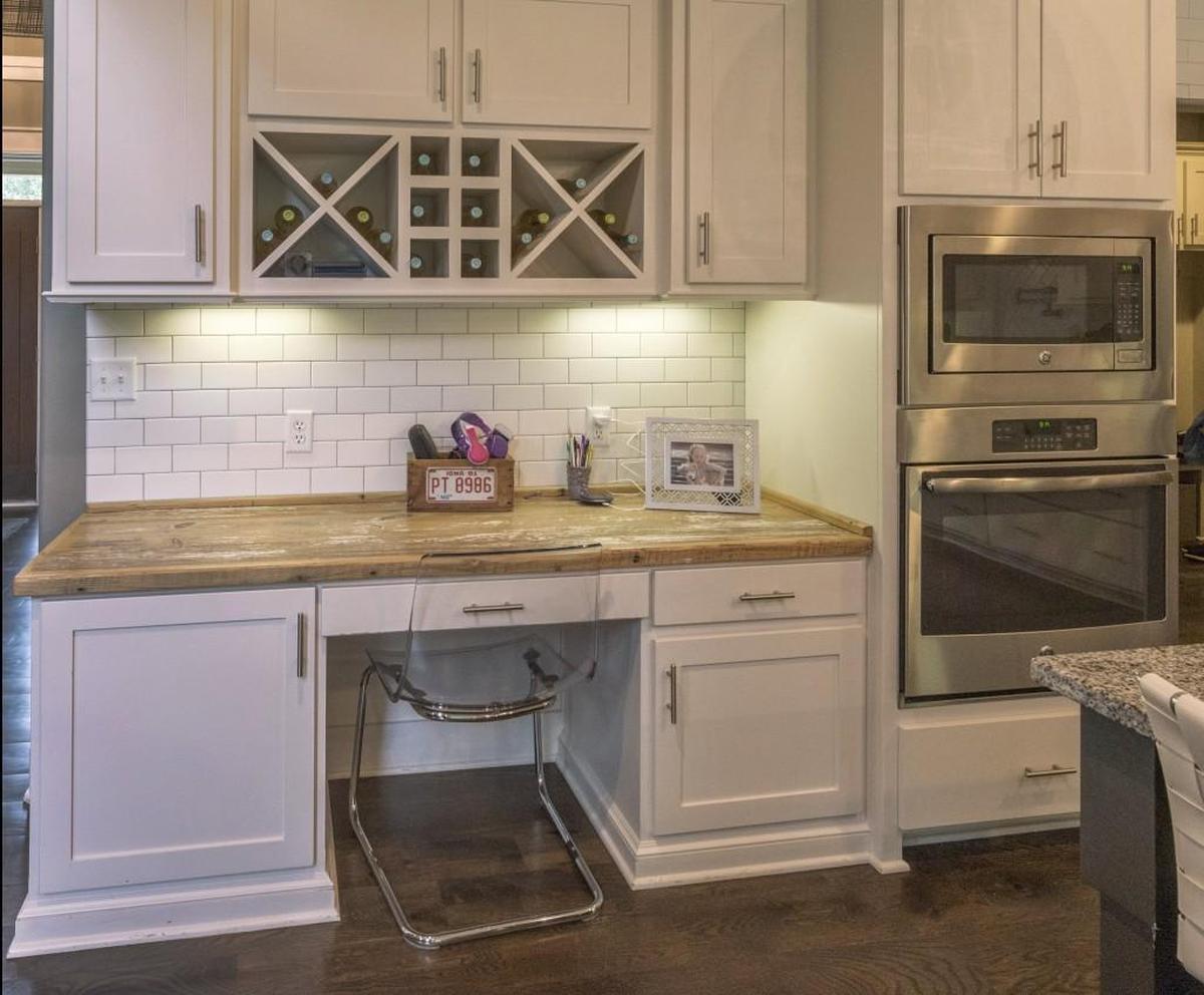 The rustic kitchen desk top merges perfectly with the contemporary appliances and cabinetry.