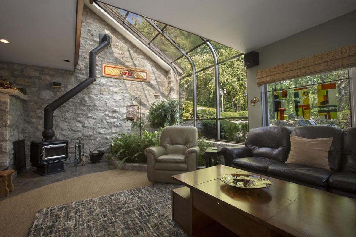 Tom Smith’s favorite addition is the stone-foundation greenhouse with live ferns and a wood-burning stove. He says the space has been used for several purposes, including dining room and yoga studio, before it was his man cave.