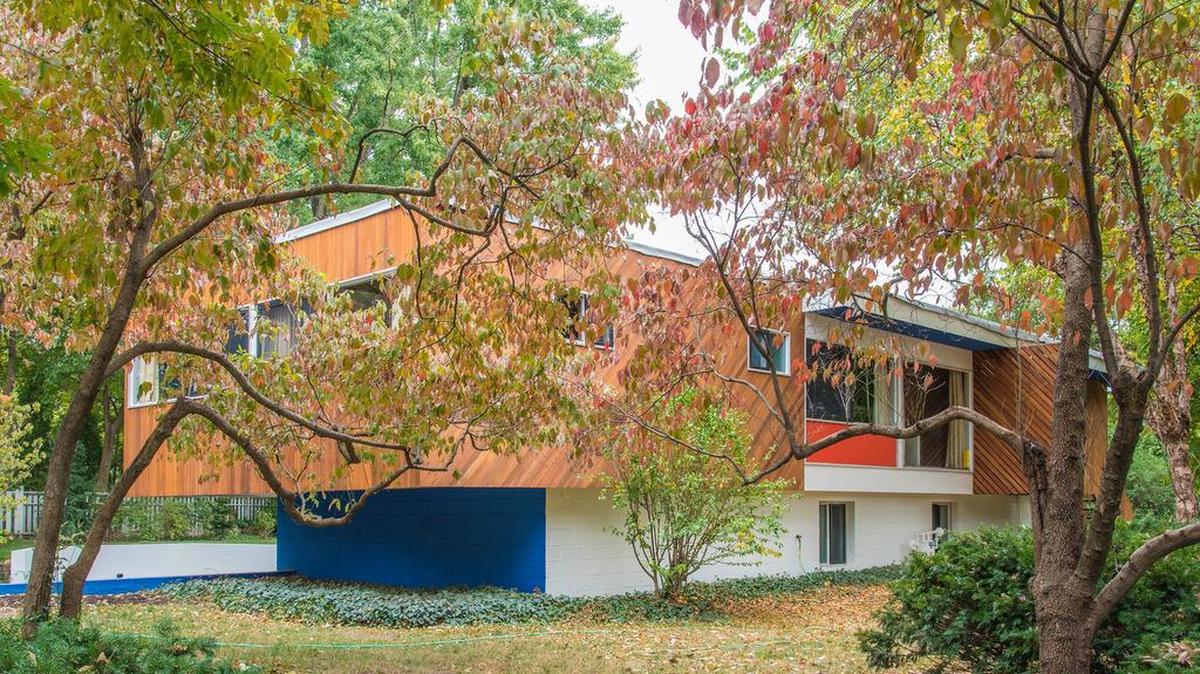 
The home’s main floor cantilevers out over its basement on the west side. The orange and blue paint colors were specified by Breuer. The cedar was recently restored from a dark brown to its original light color. 
