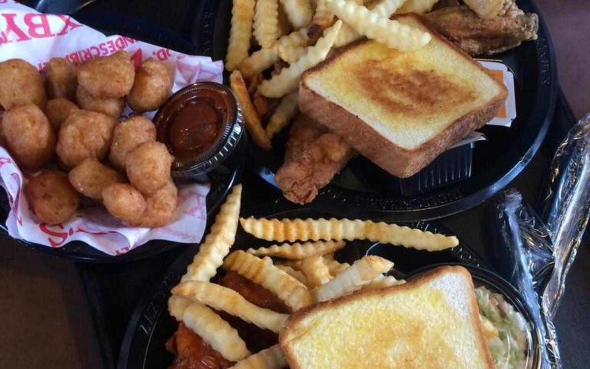 A tradition chicken wings plate, a sauced chicken tender plate and fried white cheddar cheese appetizer with marinara.