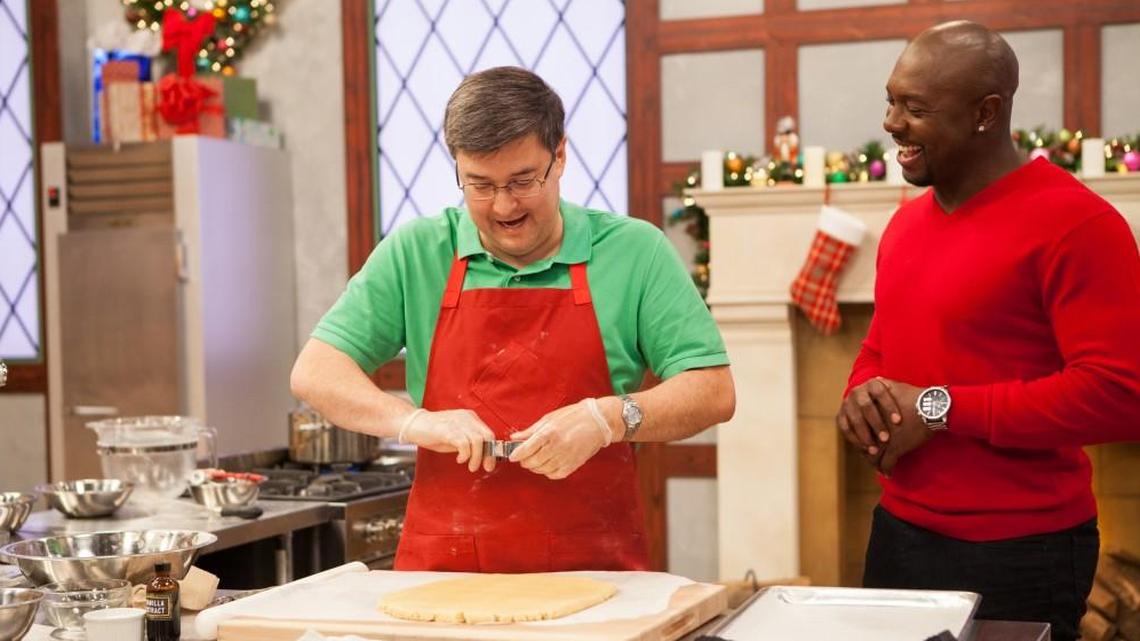 Host Eddie Jackson watches over Overland Park’s Robert Duensing as he makes a Things That Go-themed soft butter shortbread car and sleigh cookie on “The Christmas Cookie Challenge.”