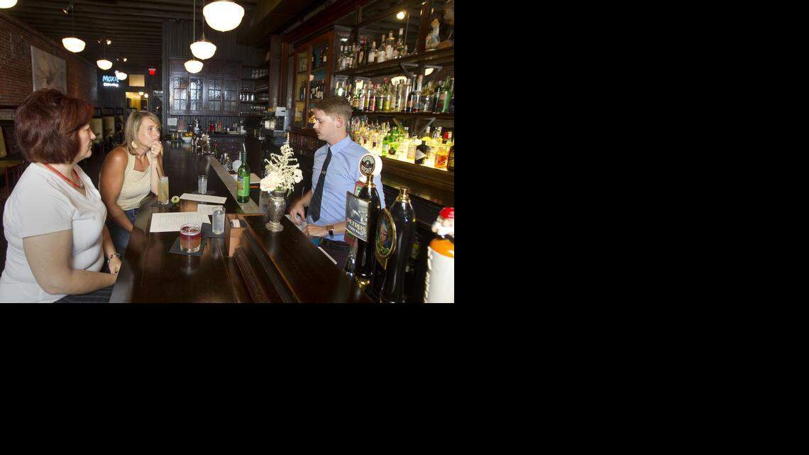 
Jean McConnell (left) and Jill Kelley, both of Overland Park, have drinks at Voltaire, 1617 Genessee in the West Bottoms where bartender Ryan Miller talked cocktails with the pair.
