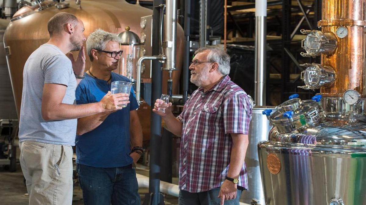 
J. Rieger head distiller Nathan Perry (left) and Steve Olson worked with Tom Nichol (right), retired master distiller for Tanqueray, who took in the aroma of a glass of gin recently while the pair were preparing a batch at the J. Rieger distillery in the East Bottoms.
