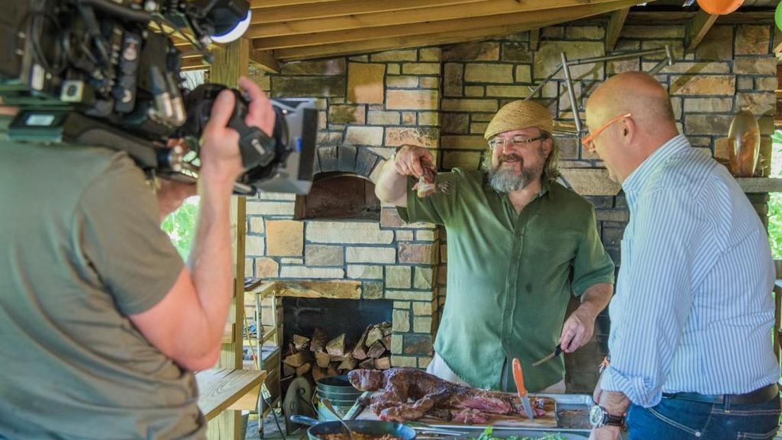 Chef Jonathan Justus carves the roasted woodchuck under the attentive eyes of “Bizarre Foods” host Andrew Zimmern.