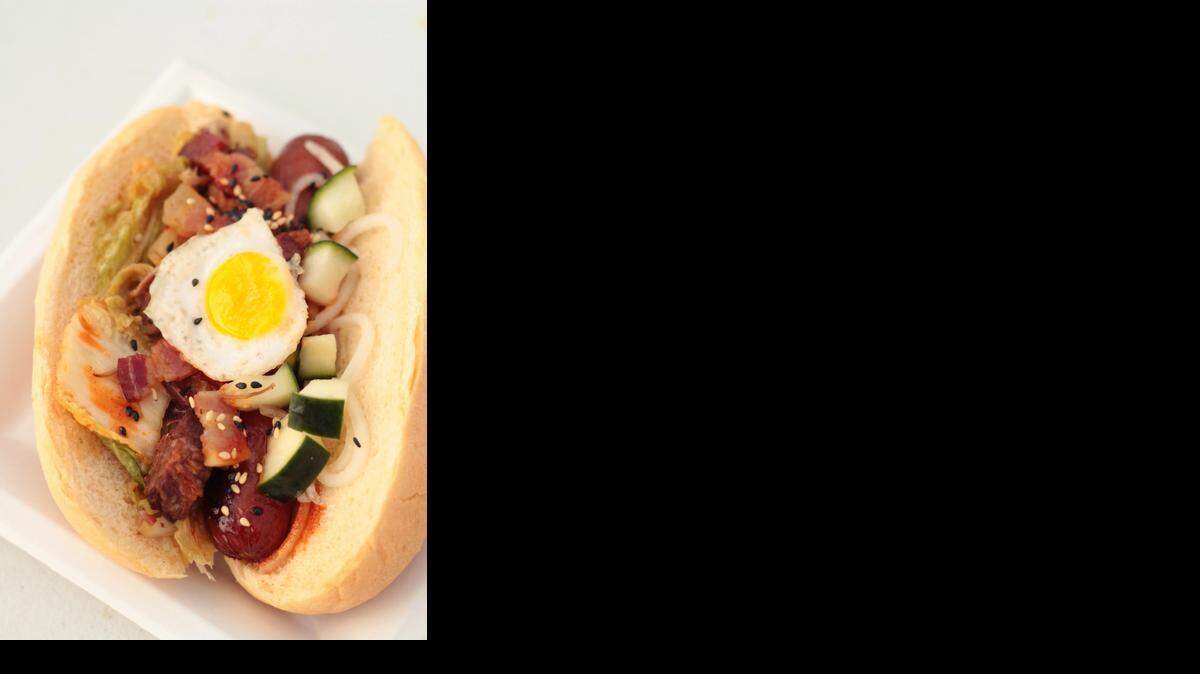 
The SungWoo Dog — a grilled and beer-braised hot dog with kimchi, bacon, smoked burnt ends, pickled daikon and cucumber, sesame seed, Korean-KC BBQ sauce and fried quail egg
