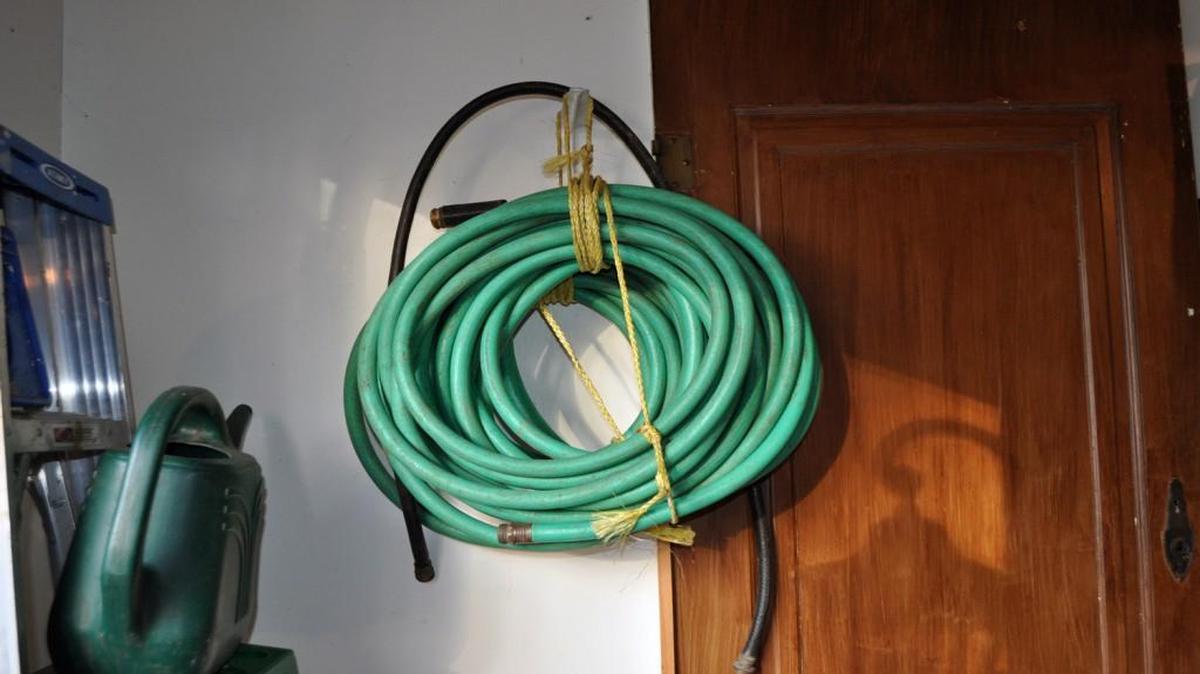 Storing a garden hose in the garage for the winter.