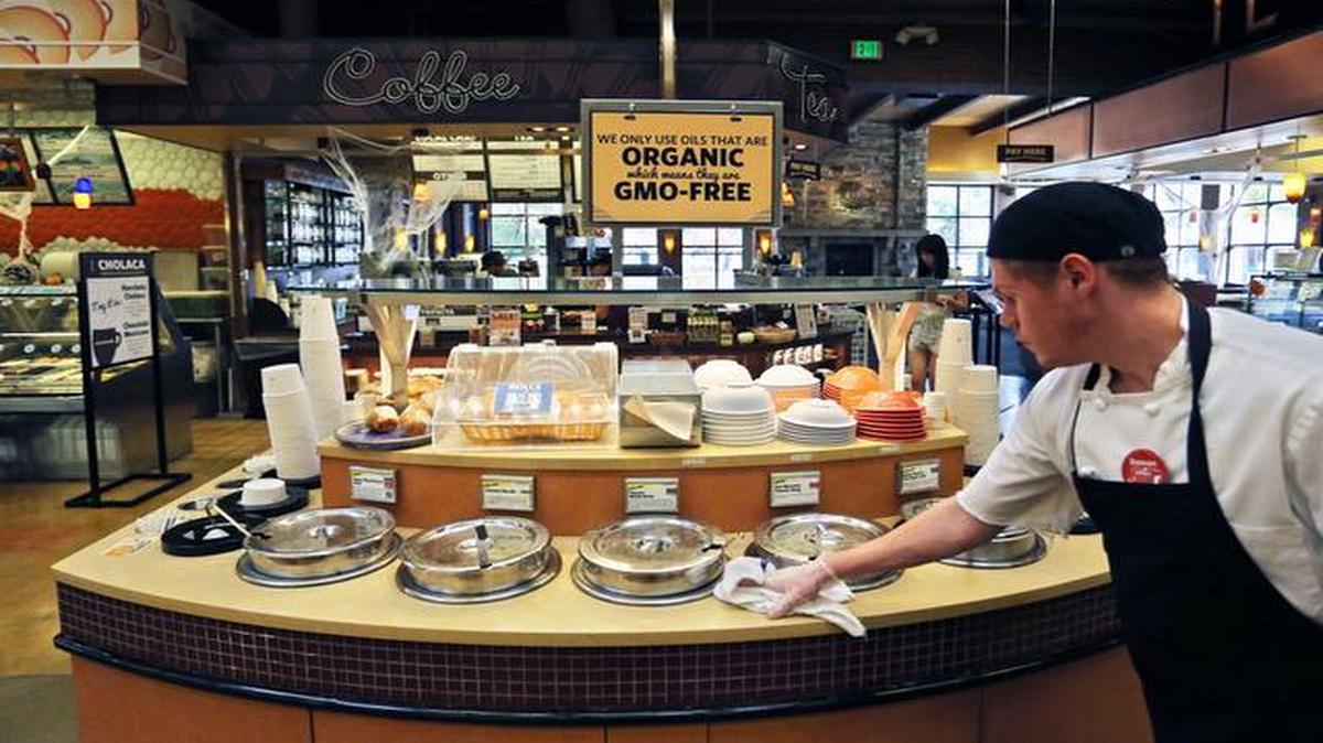 
A grocery store employee wiped down a soup bar with a display informing customers of organic, GMO-free oils in October in Boulder, Colo. 
