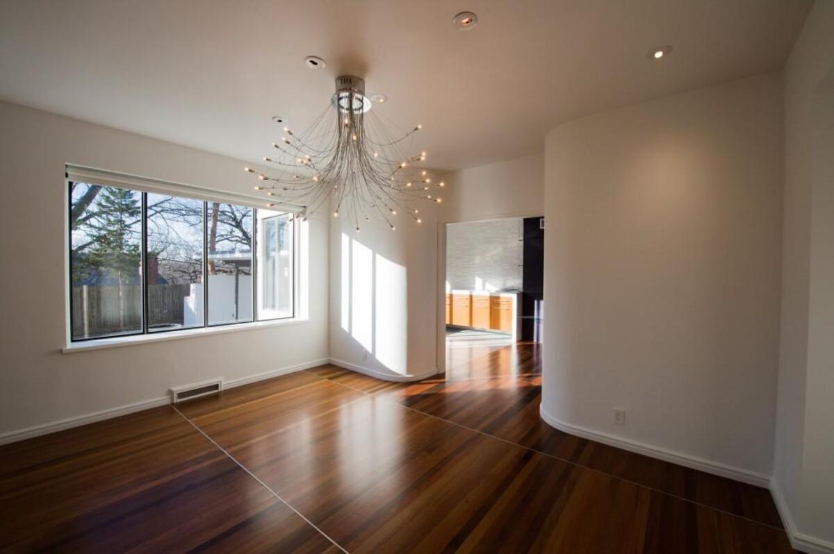 The living room is open to the dining room, which sports a large, modern chandelier.