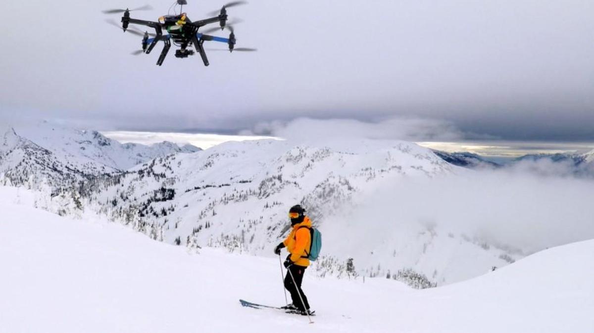 A drone hovers over a skier as he makes his way down a mountain at the Revelstoke Mountain Resort in British Columbia. Some U.S. ski resorts are exploring the possibility of “drone zones” where professionally operated drones can produce customized video that show off individuals skiers in action.