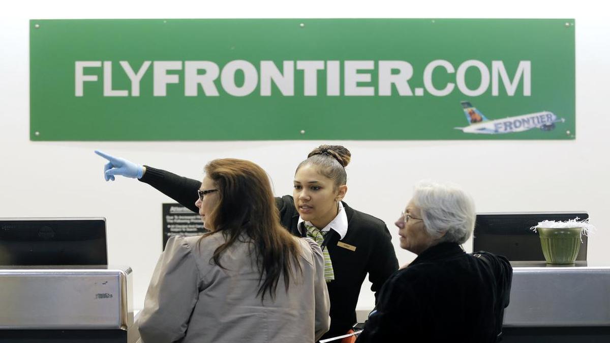 A Frontier Airlines employee directs passengers at Cleveland Hopkins International Airport in Cleveland.