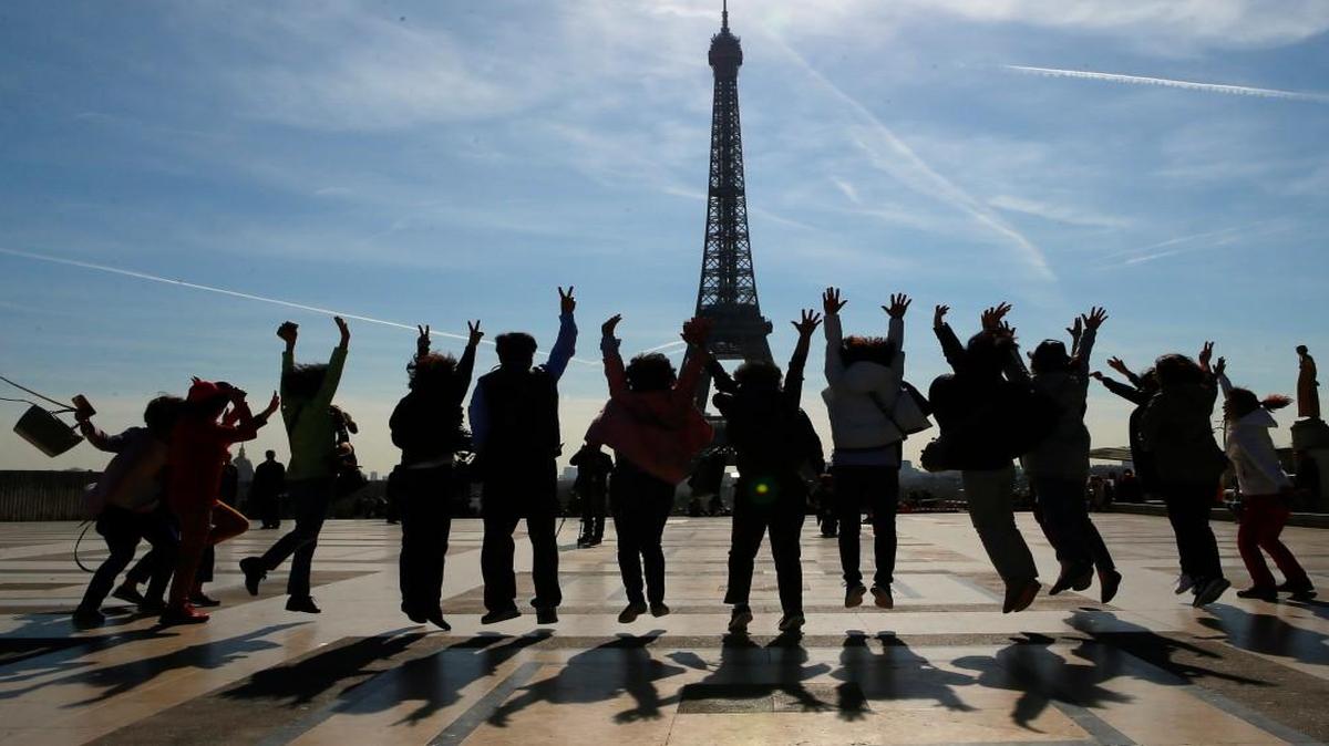 Tourists pose for a souvenir photo on Trocadero with the Eiffel Tower in background on a sunny day in Paris, Thursday, March 30, 2017. If you’ve always wanted to stroll the streets of Paris, but didn’t have thousands to spend, it’s time to act fast.