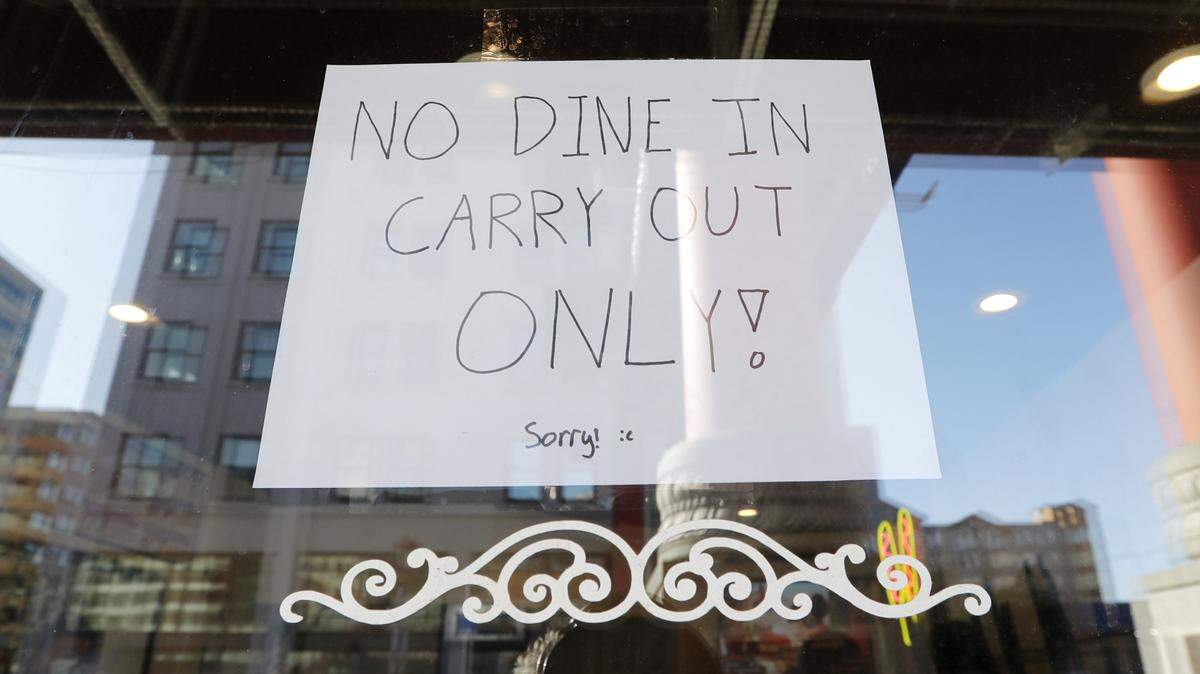 A sign posted in a restaurant window in the Chinatown-International District advises of only take out orders Monday, March 16, 2020, in Seattle. Washington Gov. Jay Inslee on Monday ordered all bars, restaurants, entertainment and recreation facilities to temporarily close to fight the spread of the new coronavirus in the state with by far the most deaths in the U.S. from the COVID-19 disease. Take out and delivery food orders are still allowed. (AP Photo/Elaine Thompson)