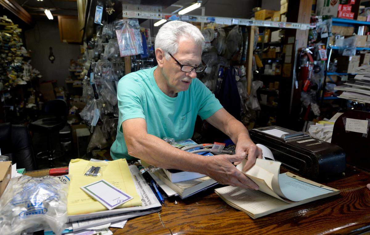 Graham checks some notes while helping a customer. His plumbing supply business moved from midtown Kansas City to Raytown in 1999.