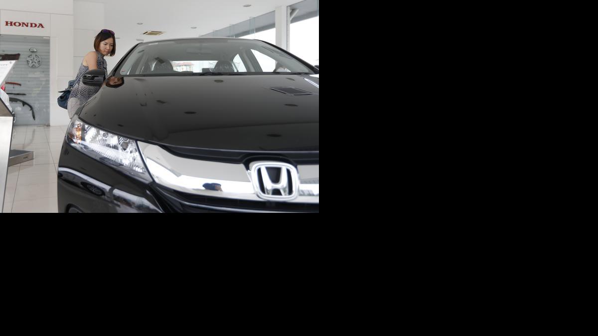 
A woman checks out a new Honda City at a showroom in Petaling Jaya, Malaysia. 
