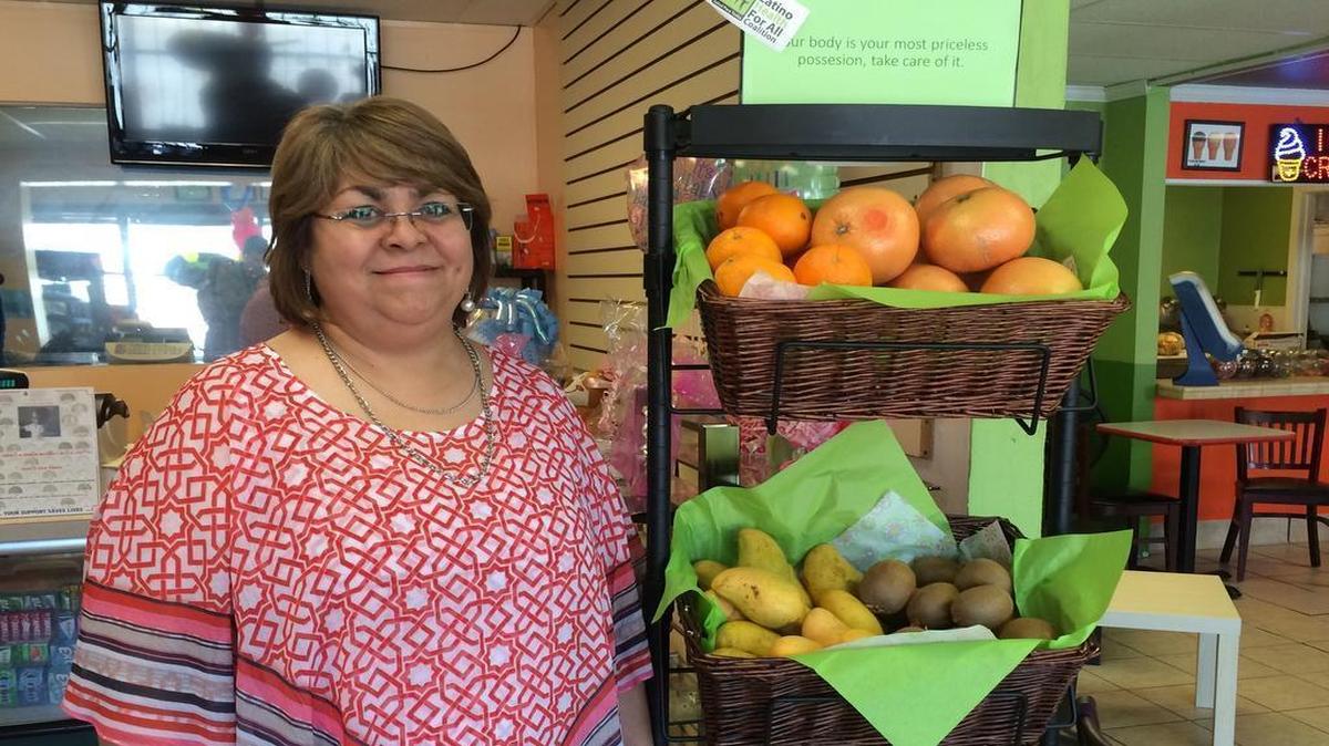 
Graciela Martinez tries to provide a welcoming personal touch when serving customers at her grocery store in Kansas City, Kan. She says a program promoting healthy food has already made a difference for her customers.
