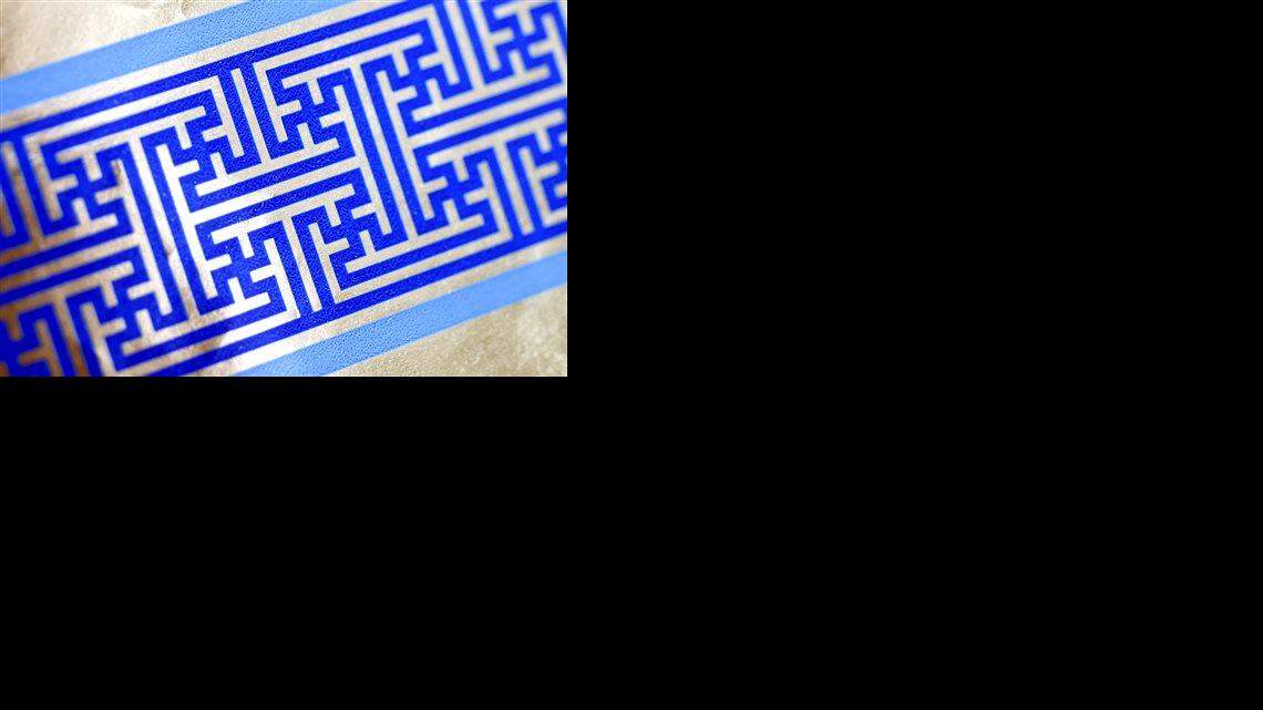 Cheryl Shapiro displays the Hanukkah gift wrap with a swastika-like pattern she found at Walgreens in Northridge, Calif., Monday, Dec. 8, 2014. The wrapping paper has been recalled from stores nationwide.