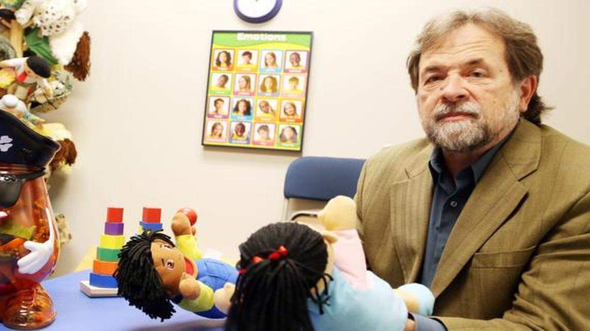 Alan Flory, at left, demonstrates puppets used in the play therapy room.<252><252>