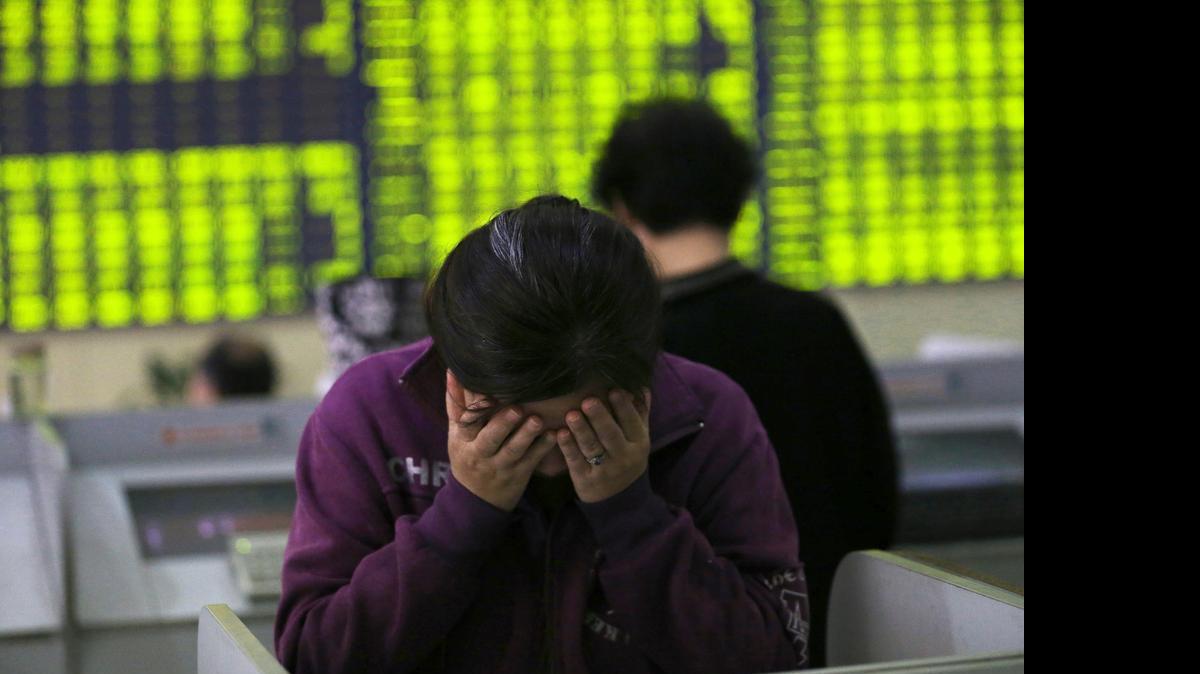 
A woman rubbed her face as she stood at a computer terminal Wednesday in a stock brokerage house in Nantong in eastern China’s Jiangsu province. China’s Shanghai Composite Index fell 5.9 percent on Wednesday.
