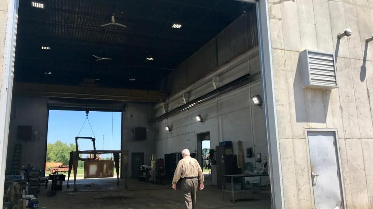 Tom Evans walks into the paint shop at Evans Equipment.