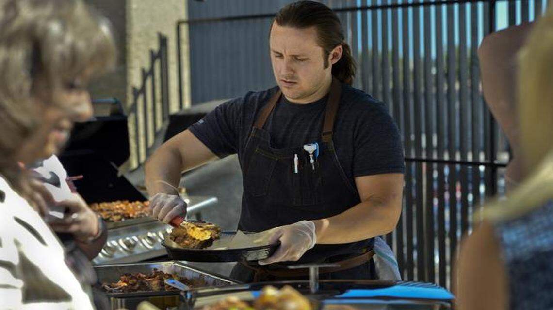 
Kyle Williams loaded plates of barbecue during the lunch hour last week in the Live Blue Kitchen and Cafe at Blue Cross and Blue Shield of Kansas City. The cooking show competitor is developing locally sourced, healthy lunches and take-home dinners for the insurance company's 800 employees.
