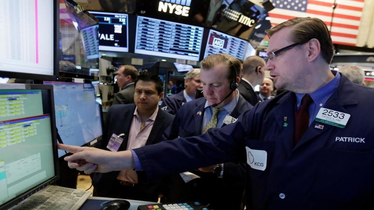 
Specialist Patrick King (right) worked with traders Friday at his post on the floor of the New York Stock Exchange.
