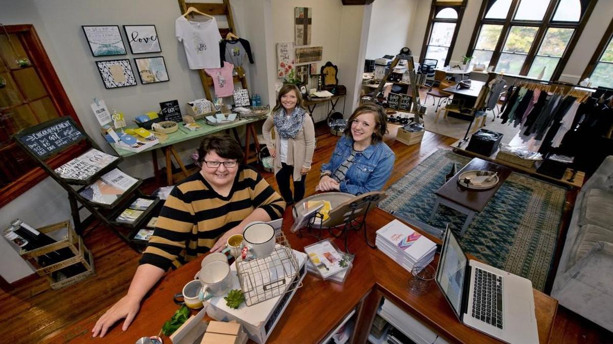 Terri Soper (from left), Carrie Flener and Kelsey Adams are three of the owners of EtchLife at 5 E. Kansas St. on the square in downtown Liberty. Their second floor shop carries Christian home decor, apparel and stationary. Kimberly Reid is the fourth partner.