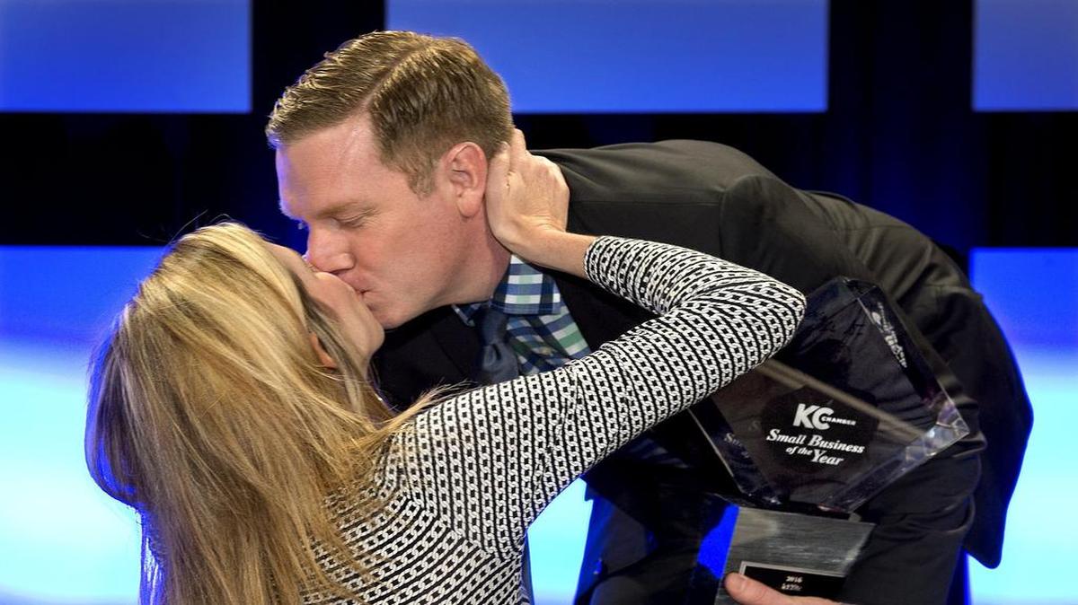 Brad Sandt got a kiss from his wife, Krista Sandt, after his k12itc was named Small Business of the Year on Wednesday by the Greater Kansas City Chamber of Commerce.