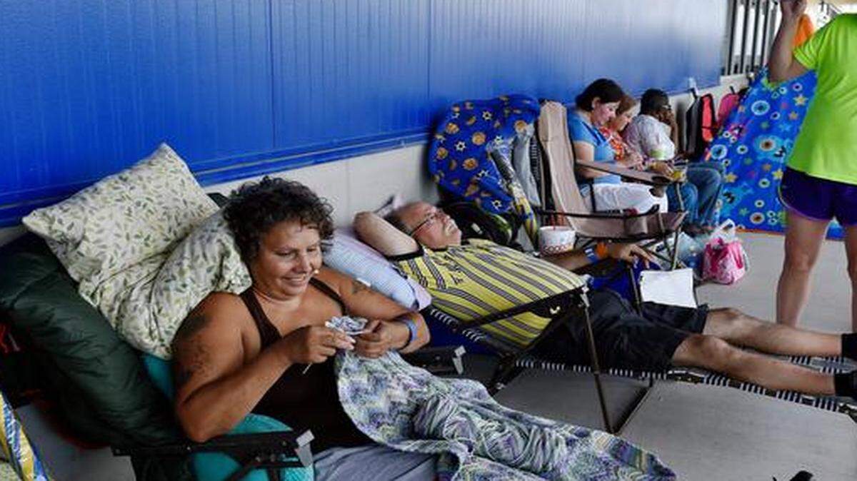 
Shoppers eager to get a free $399 couch and other free items began lining up Monday, two days before the grand opening of the area's first Ikea store in Merriam. They found different ways to pass the time. Monica Murray (from left) of Kansas City, Kan., knitted, Michael Schultz of Olathe rested and Schultz' sister Dianne Boase of Olathe danced to Abba.
